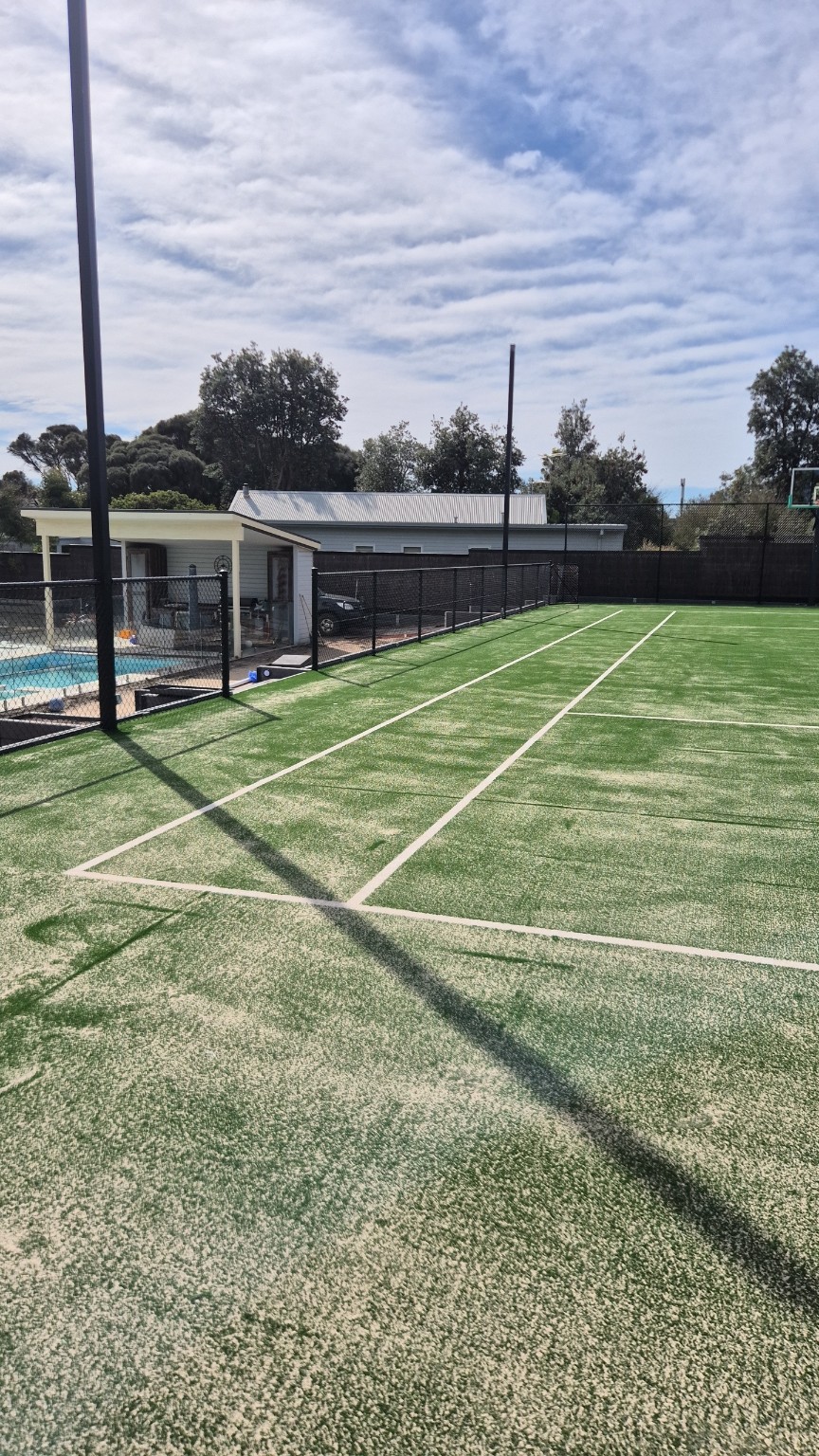 View along the low black side fence towards the high end fence at the private Blairgowrie tennis court