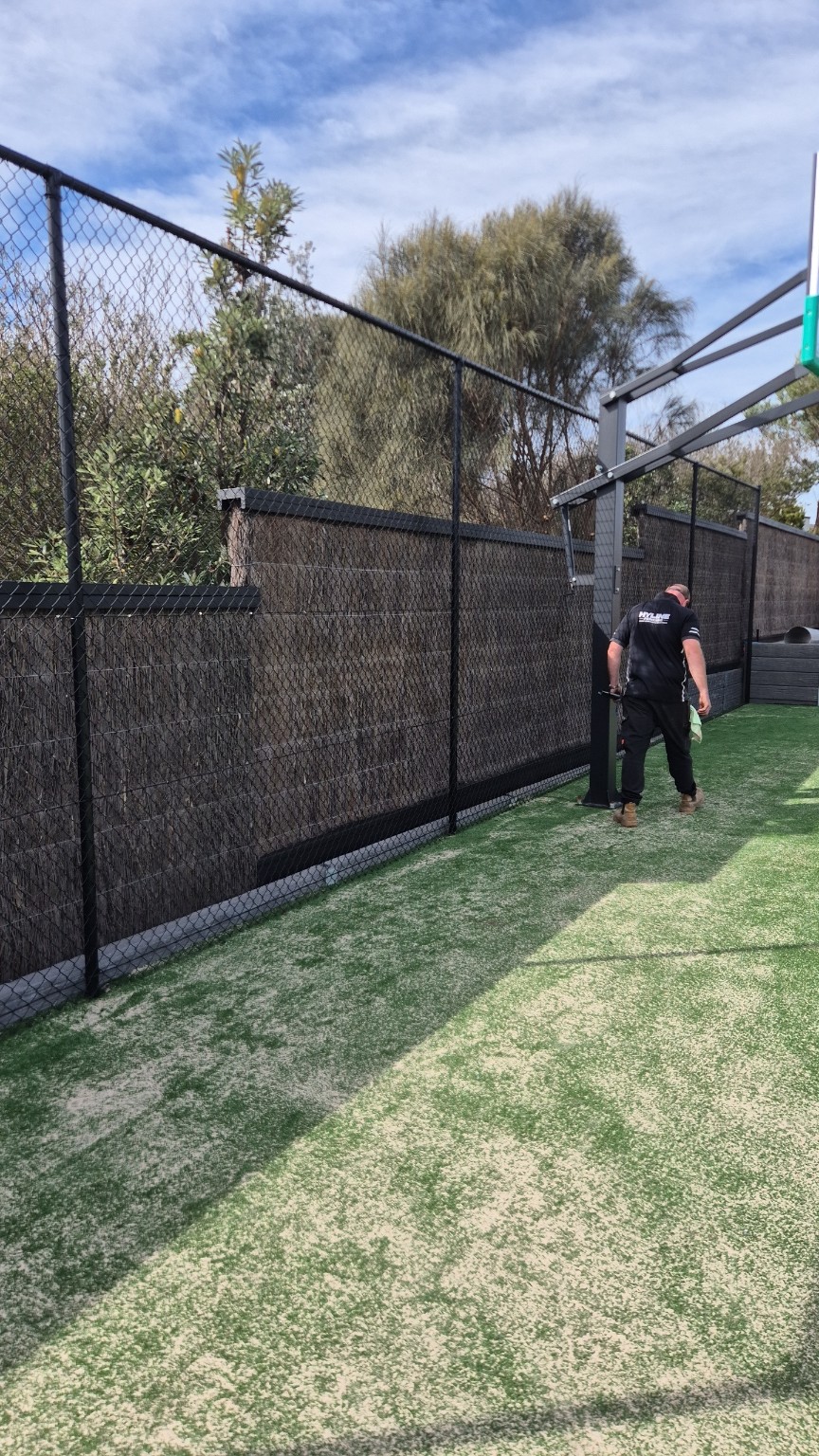 Close view of black chain mesh and top rail behind the basketball hoop at the Blairgowrie tennis court