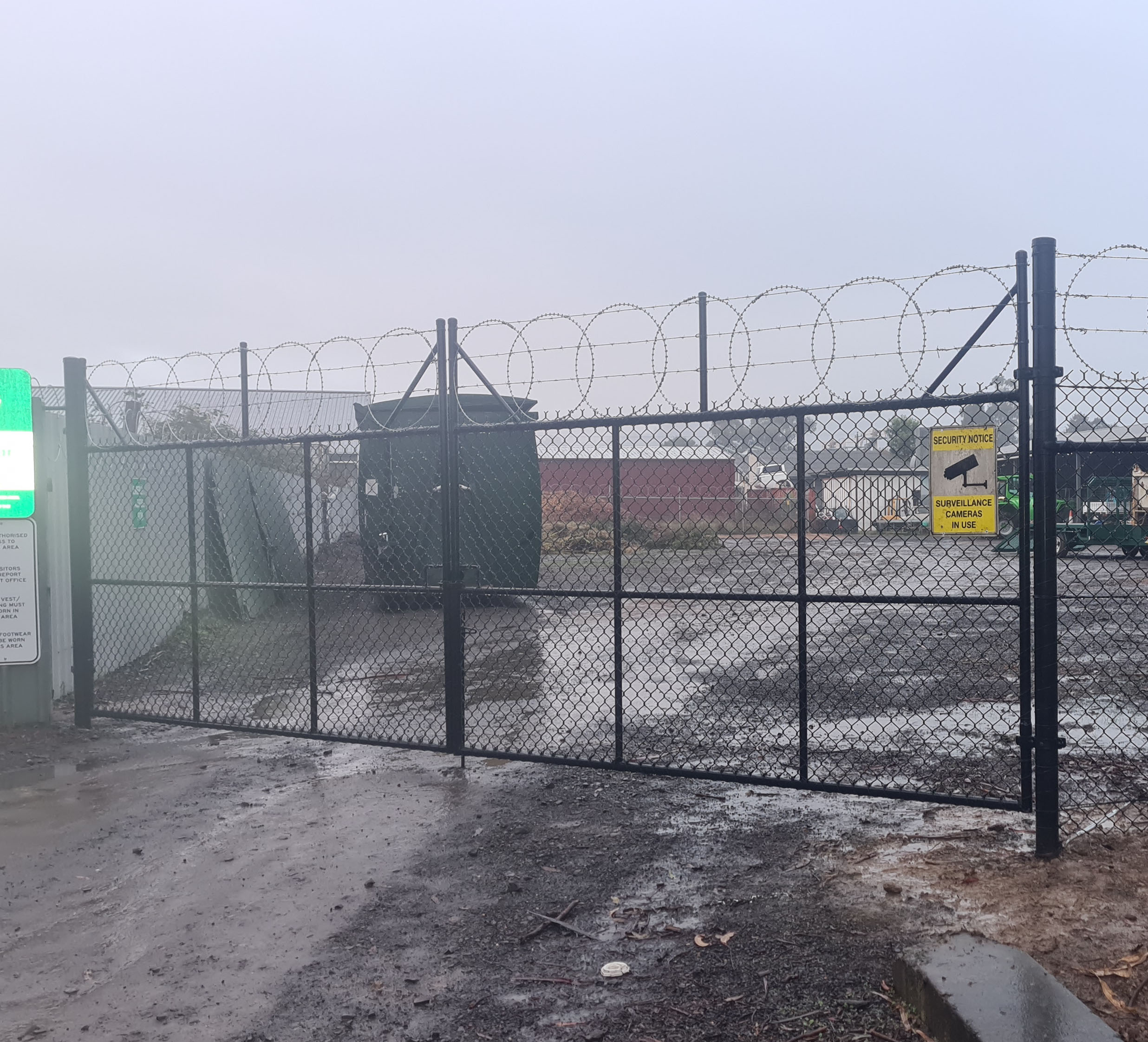 Black chain mesh pedestrian gate installed beside a skate facility