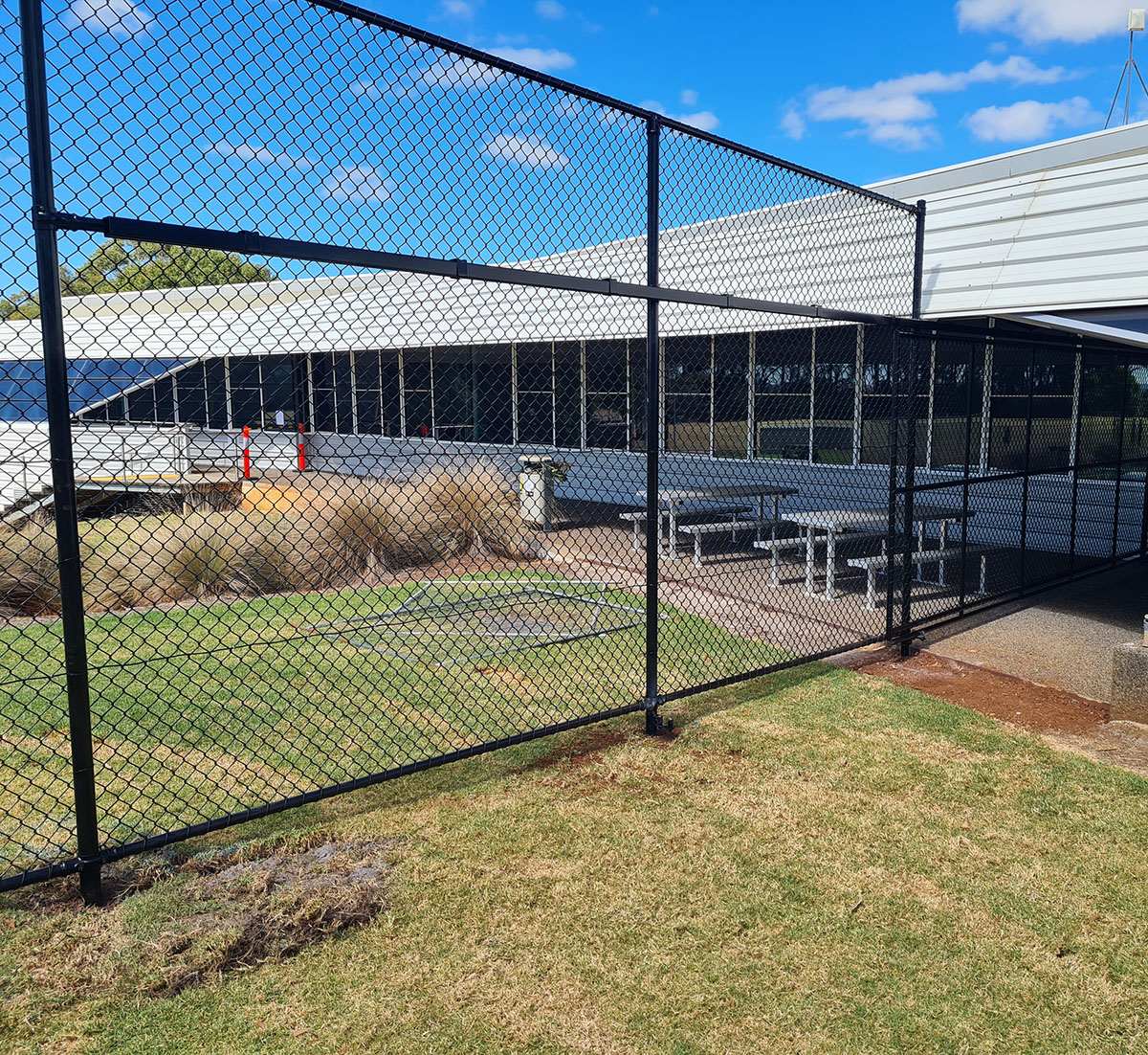 Black chain mesh access gate and enclosure around site facilities