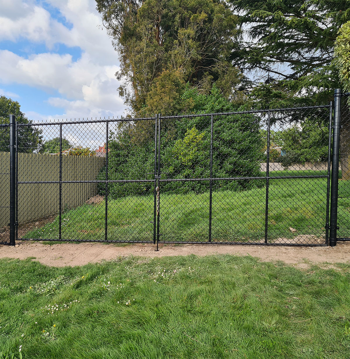 Black chain mesh pedestrian gate providing controlled path access