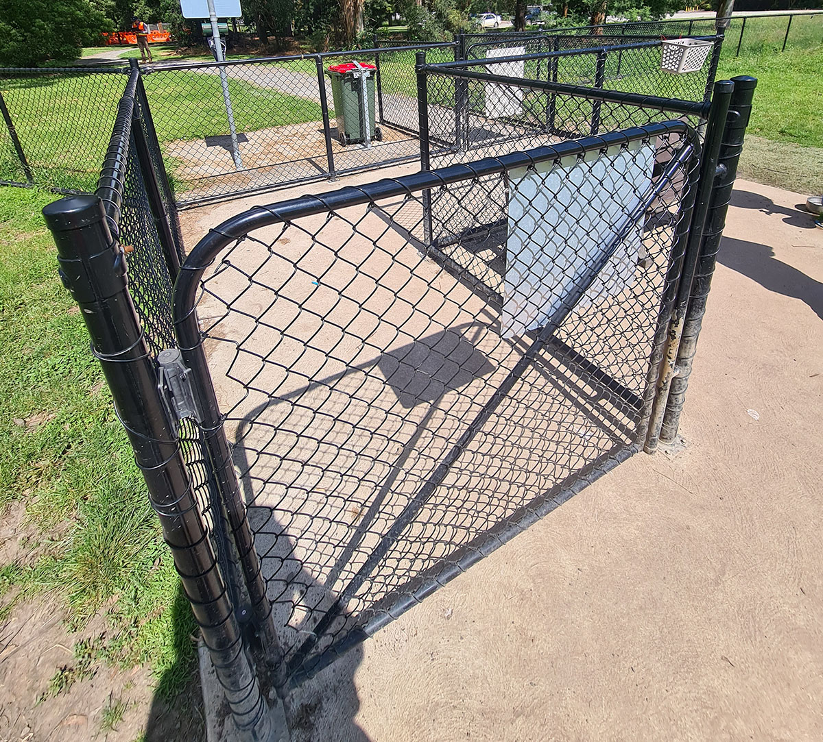 Black chain mesh fencing and gate system installed around a school or facility space
