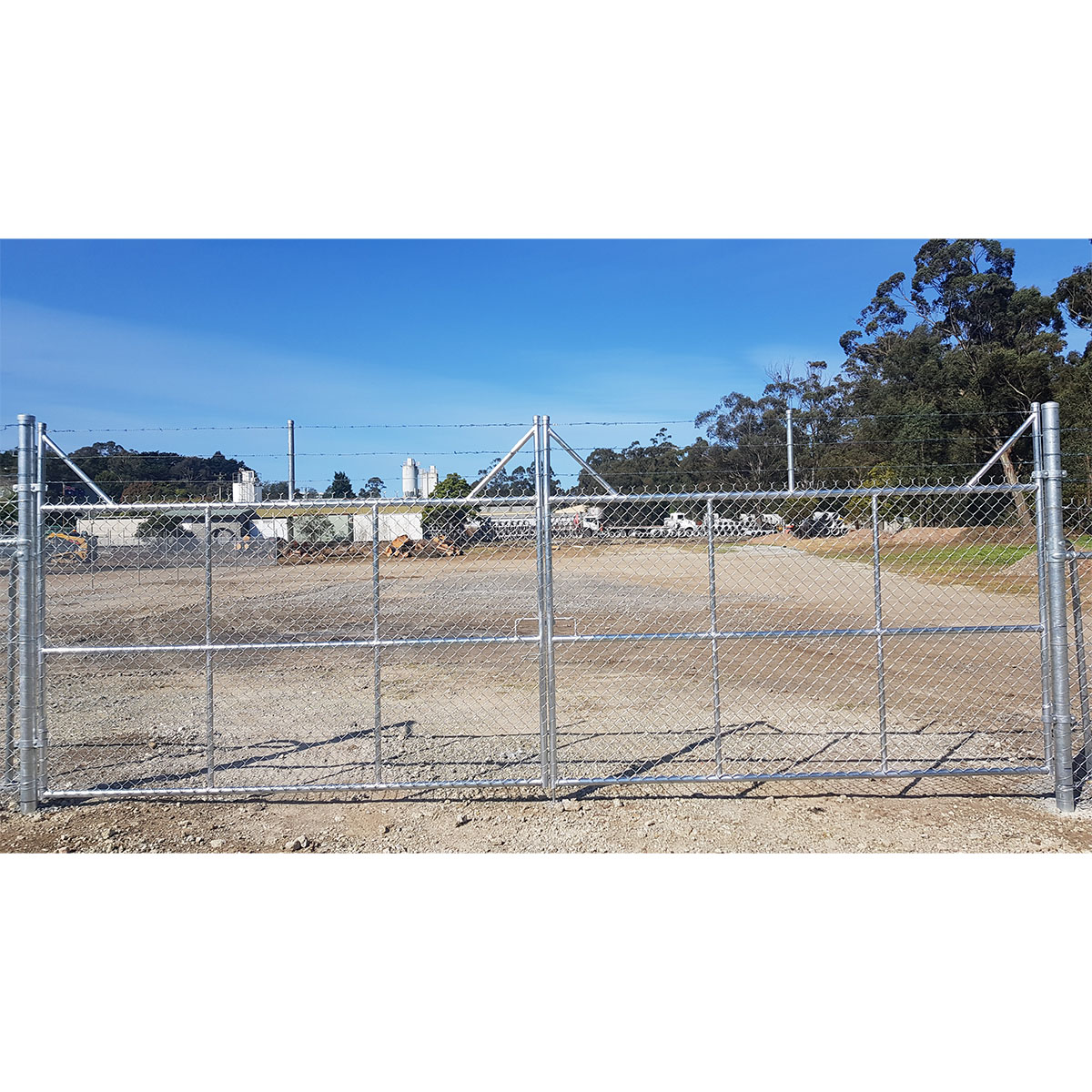Black chain mesh pedestrian gate fitted between industrial colorbond walls