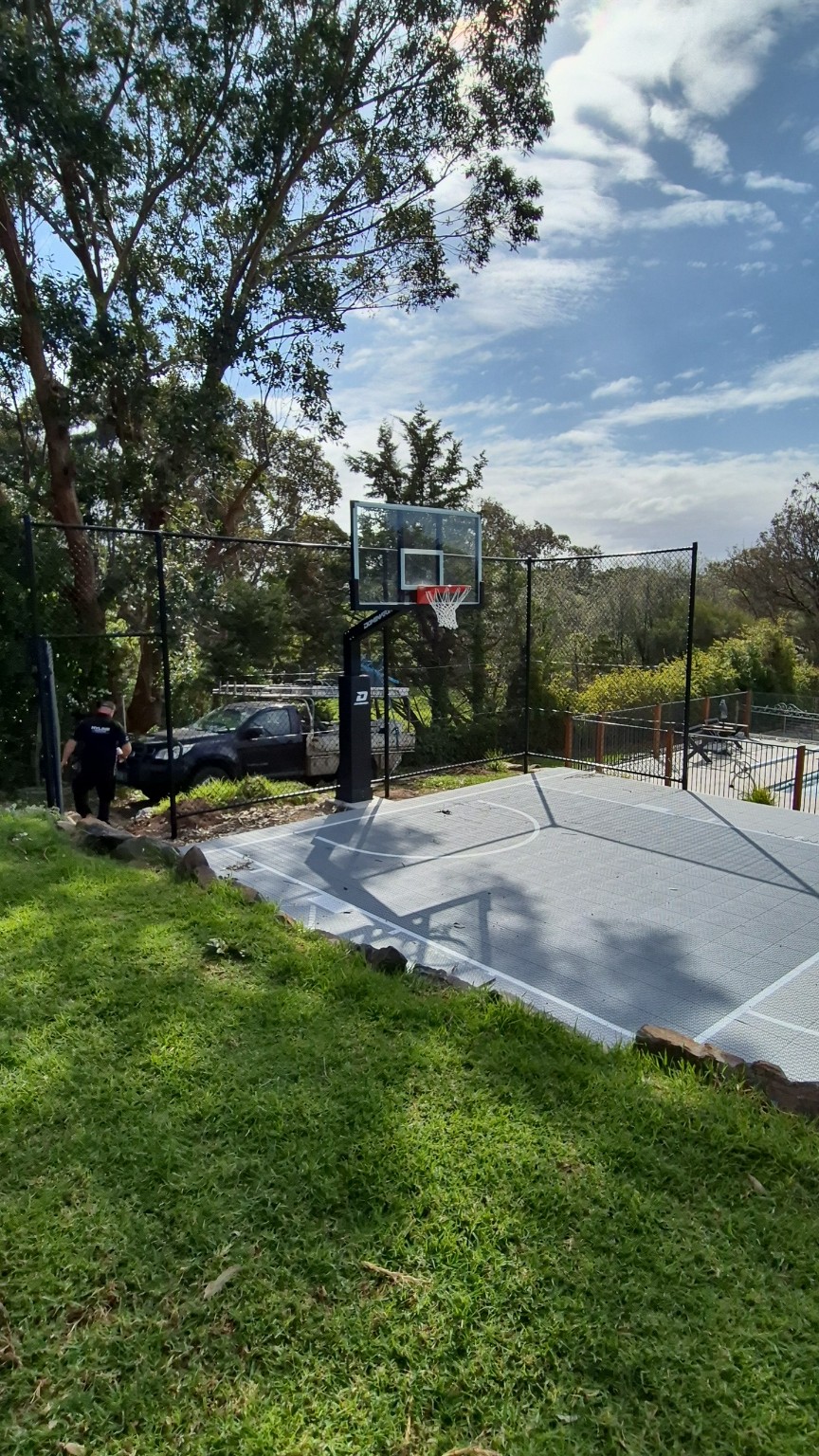Wide view of the backyard basketball court and completed 3m high black chain wire fencing in Narre Warren North