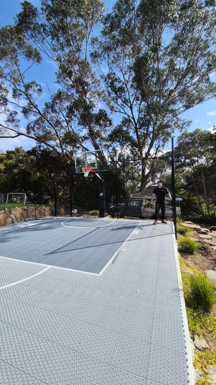 View along the backyard basketball court towards the black ball containment fence in Narre Warren North