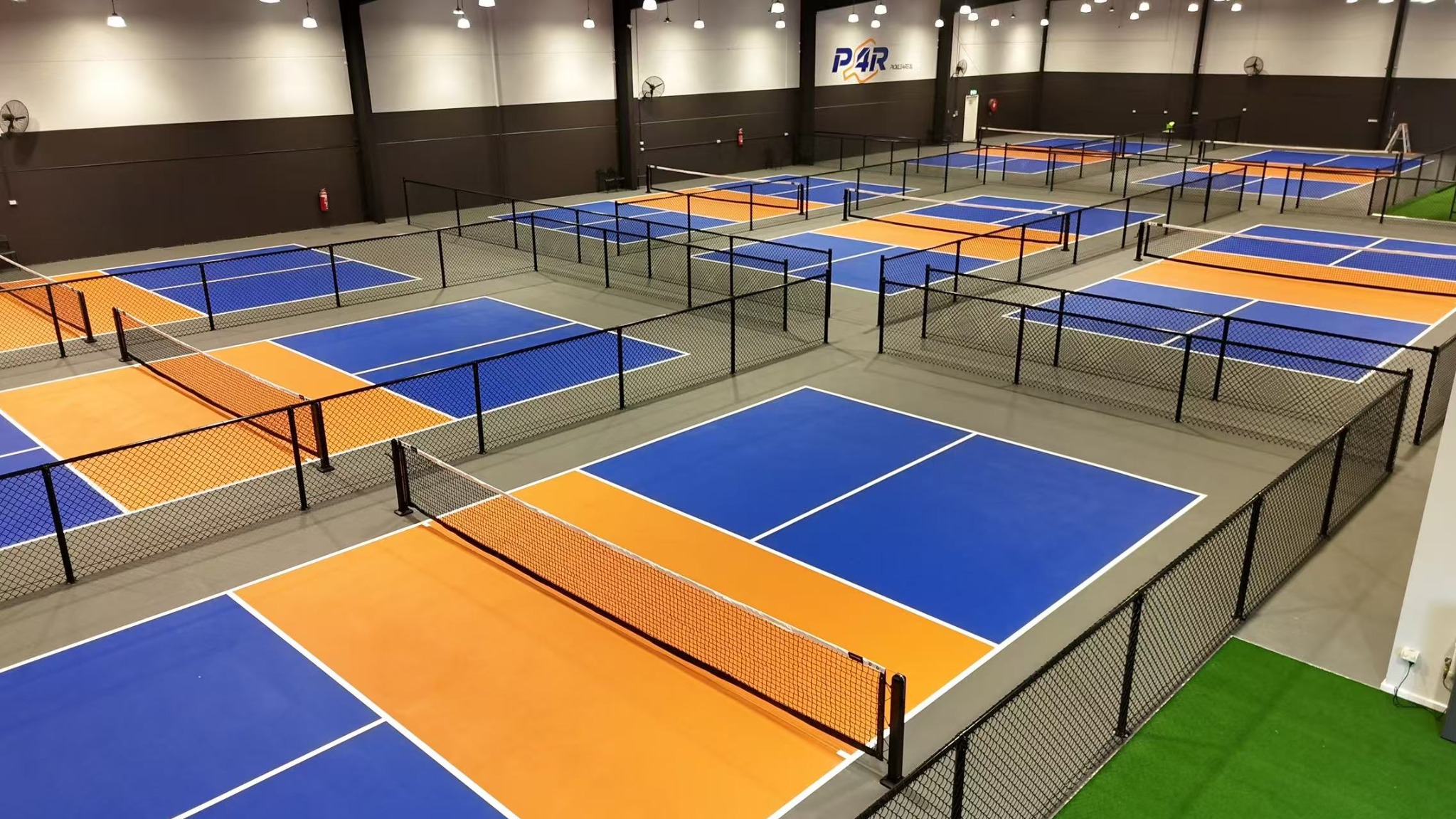 P4R Pickle 4 Real indoor pickleball courts with black chain mesh fencing