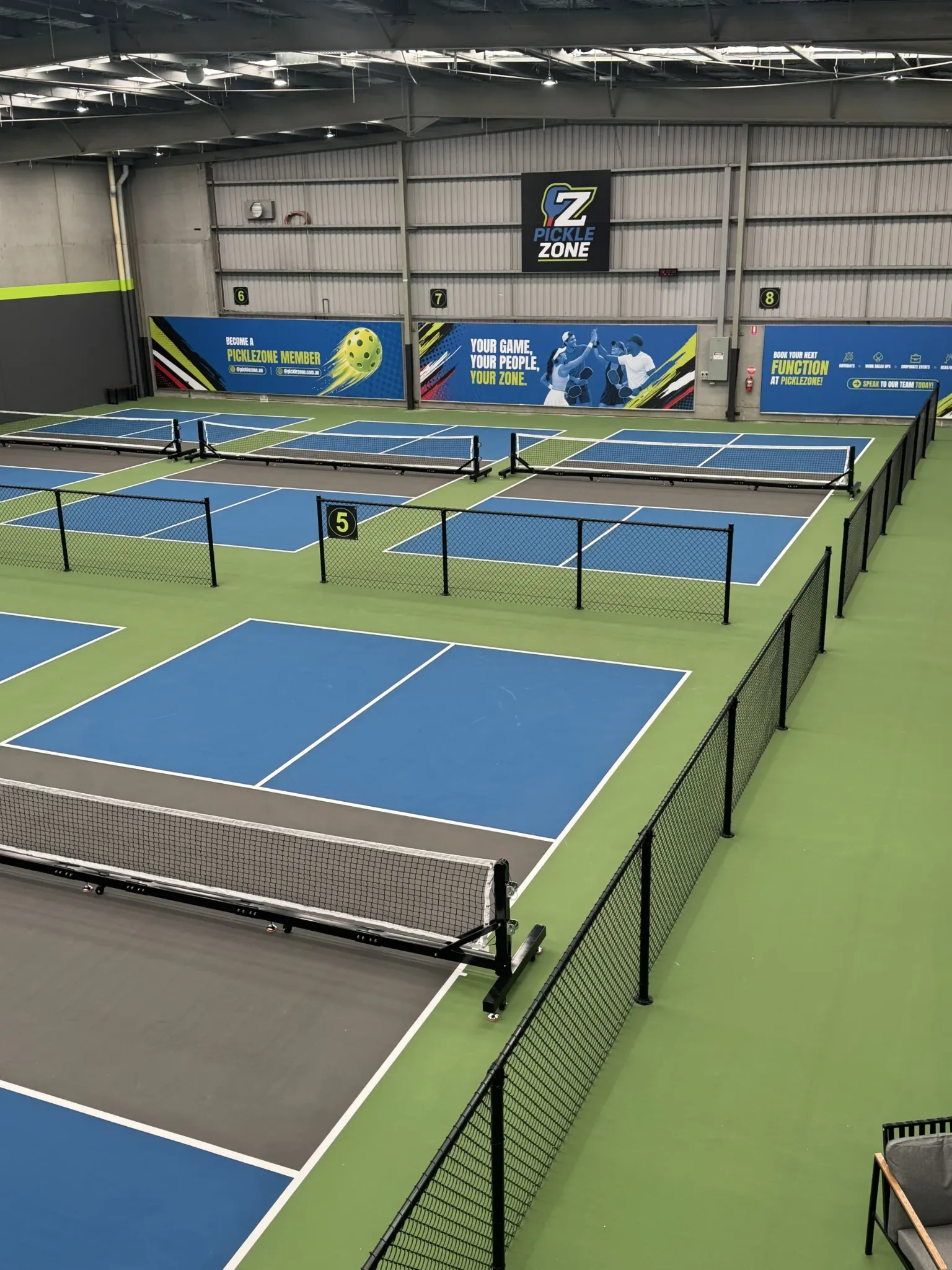 Elevated view of the fully finished Pickle Zone Springvale venue, with marked pickleball courts, nets and black chain mesh dividers