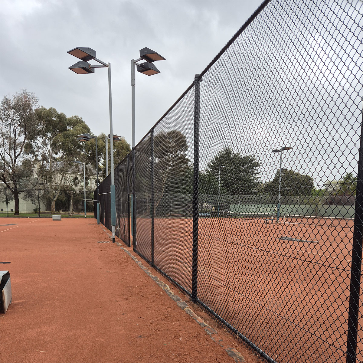 Black chain mesh boundary fencing along school grounds