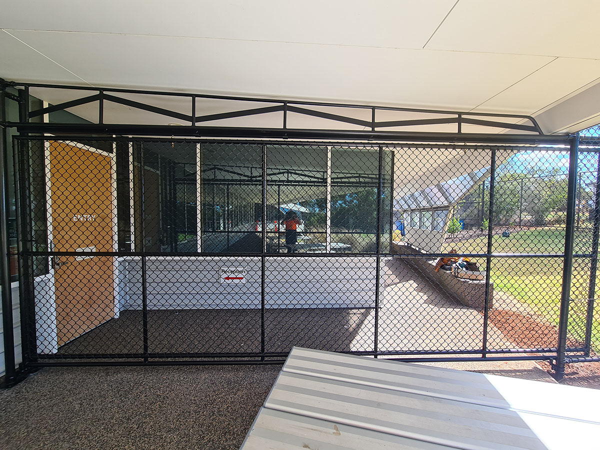School sports courts with black chain mesh fencing and internal court separation