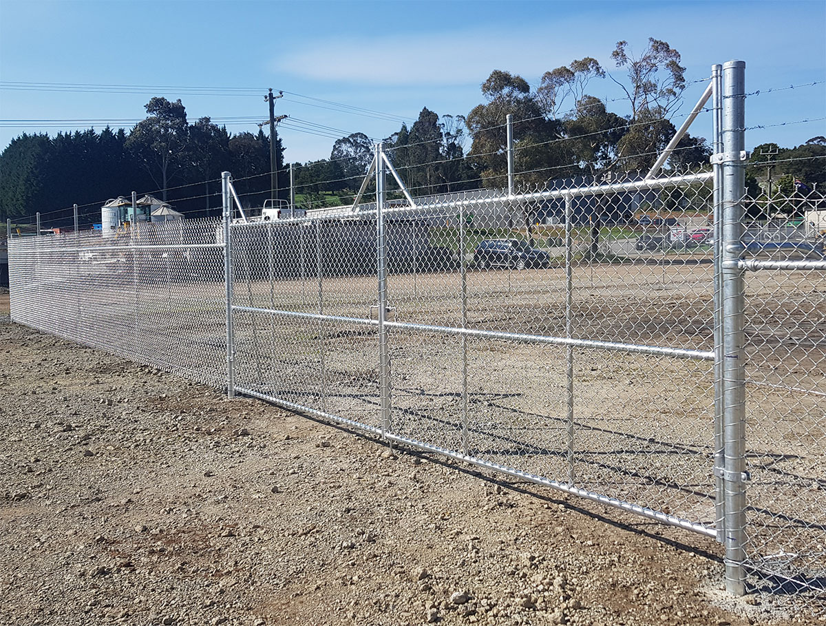 Black security fencing with gate and surveillance sign