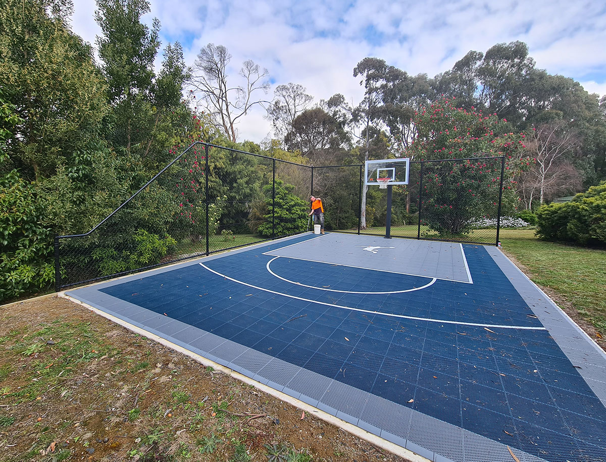 Black chain mesh sports court fencing around synthetic turf court