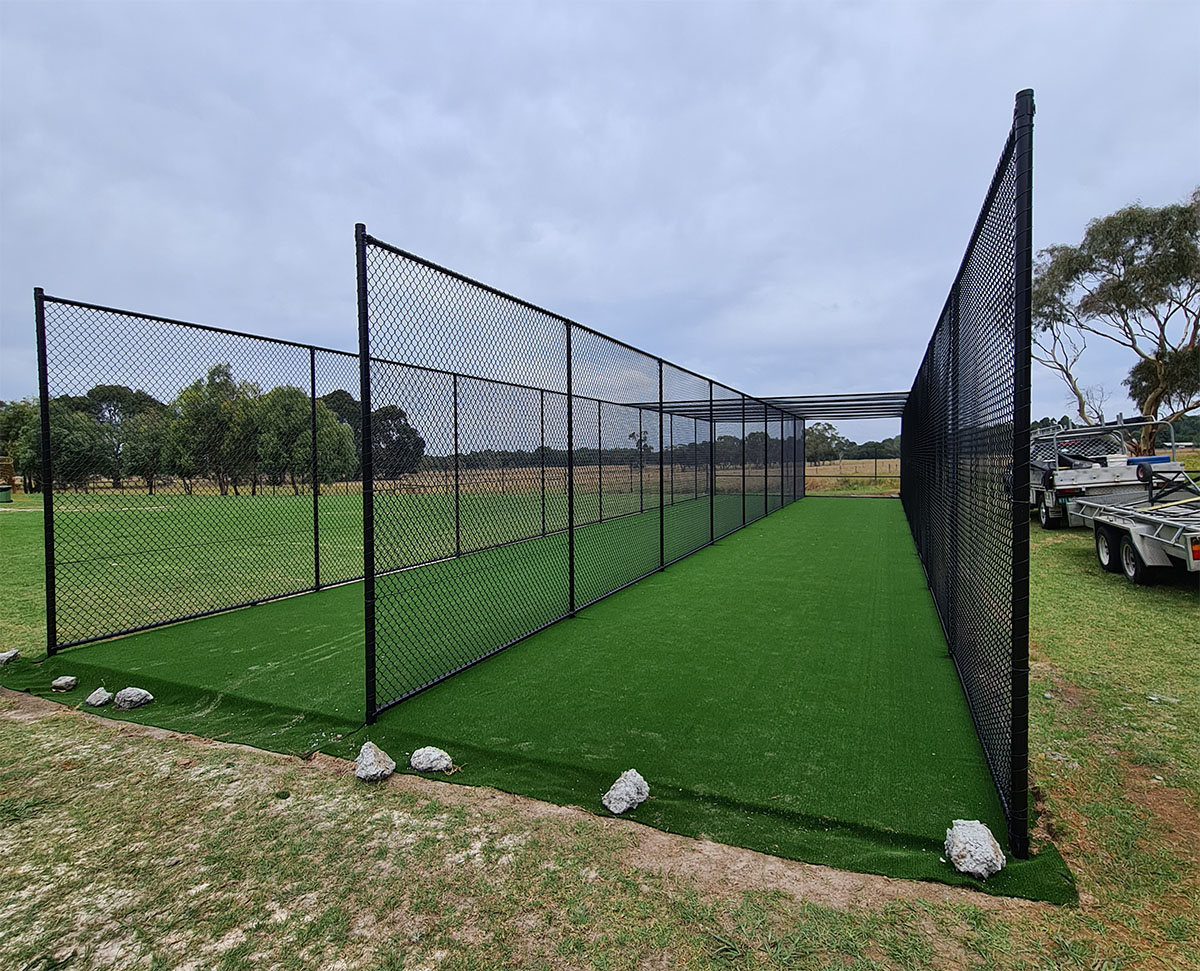 Basketball court with black chain mesh sports fencing in landscaped setting