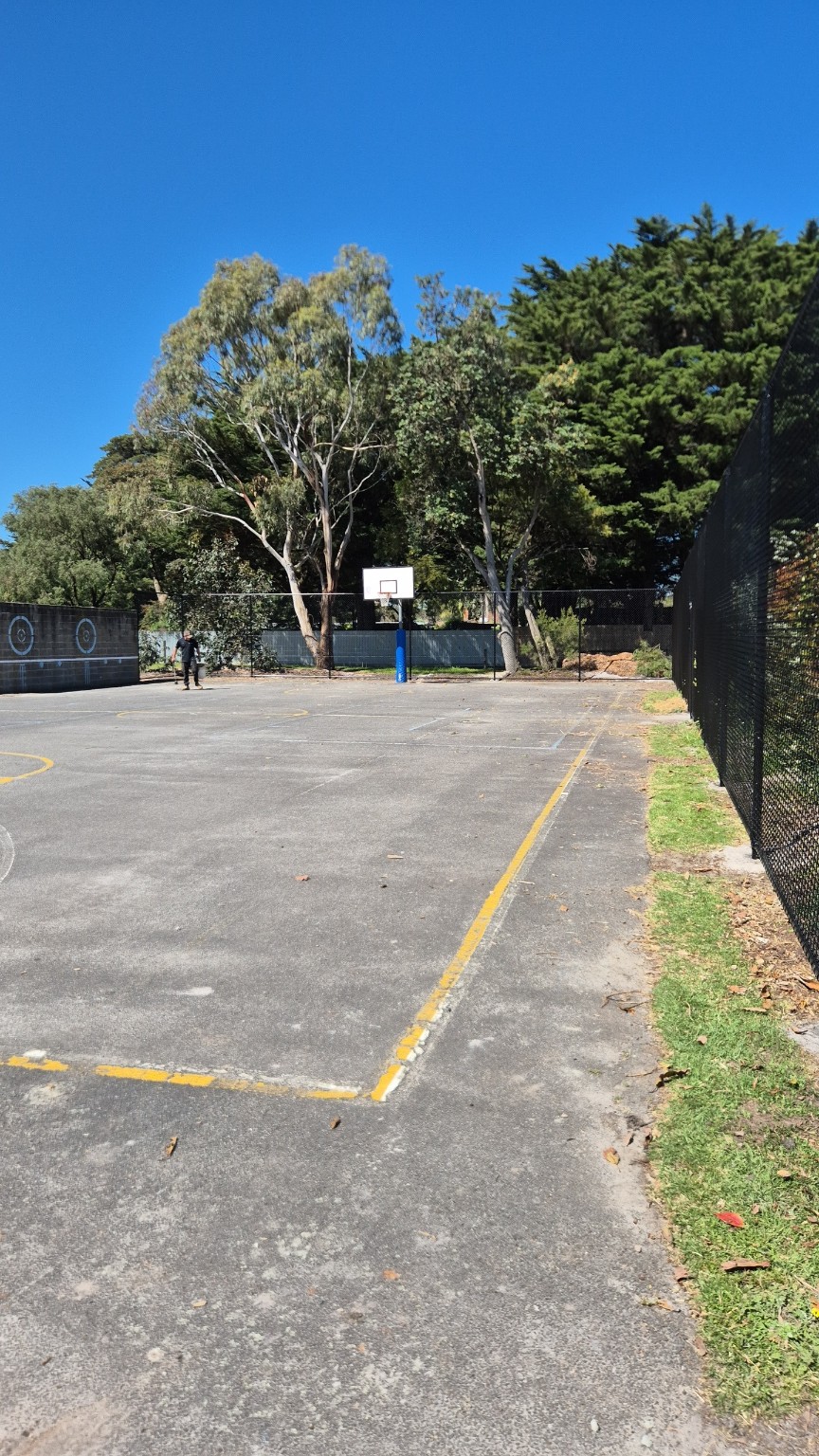 View across the basketball court towards the new black chain mesh fencing at Tarwin Lower Primary School