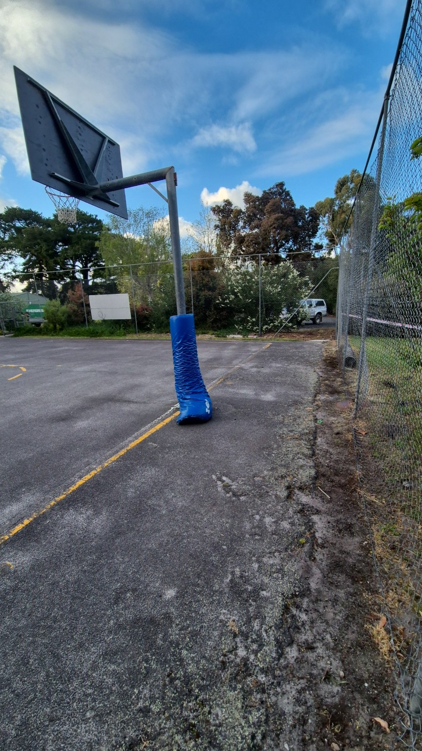 Worn galvanised chain mesh fence beside the basketball hoop before replacement at Tarwin Lower Primary School