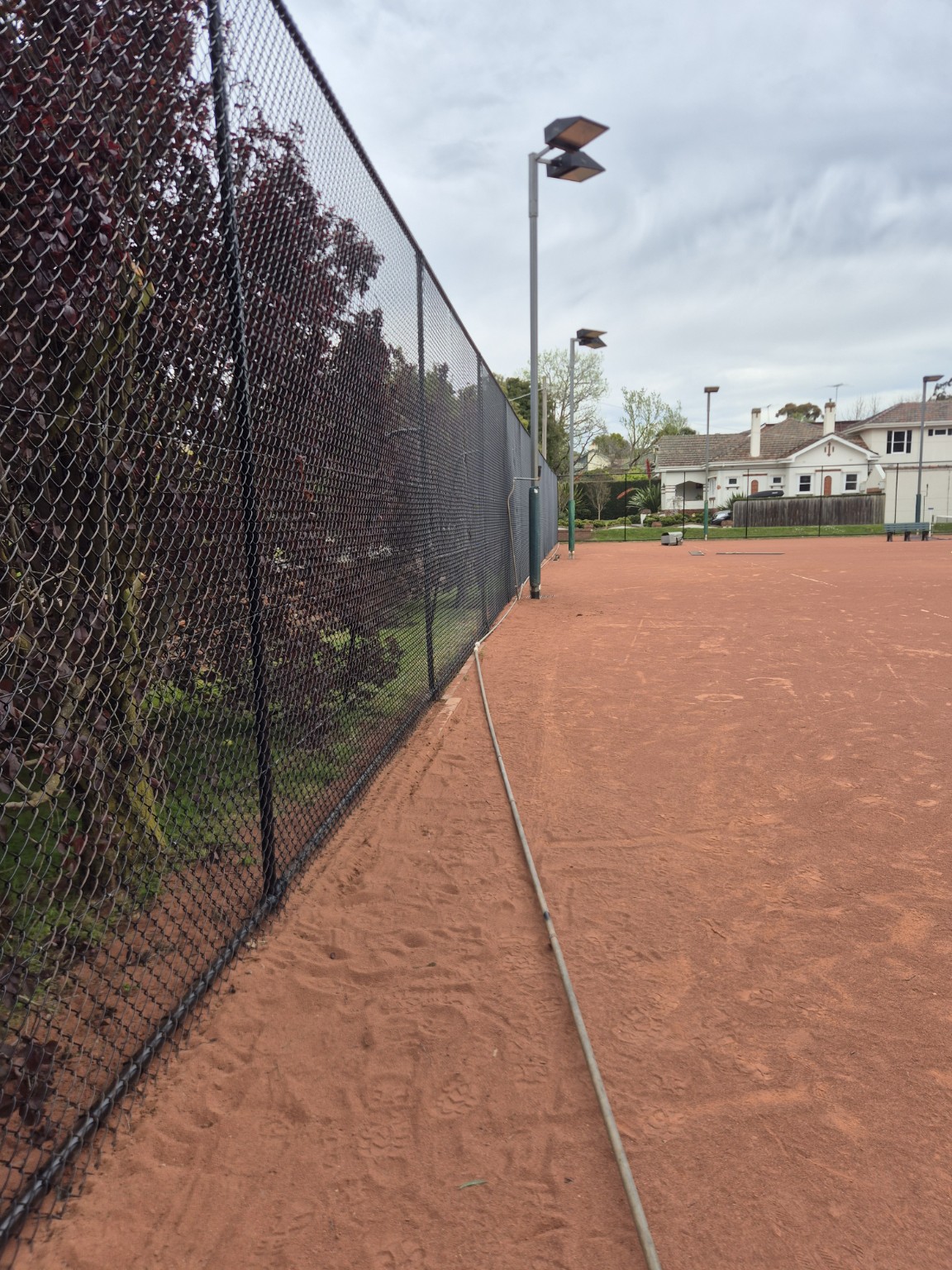 Finished black tennis court fence with repainted pipework at Willison Park Tennis Club