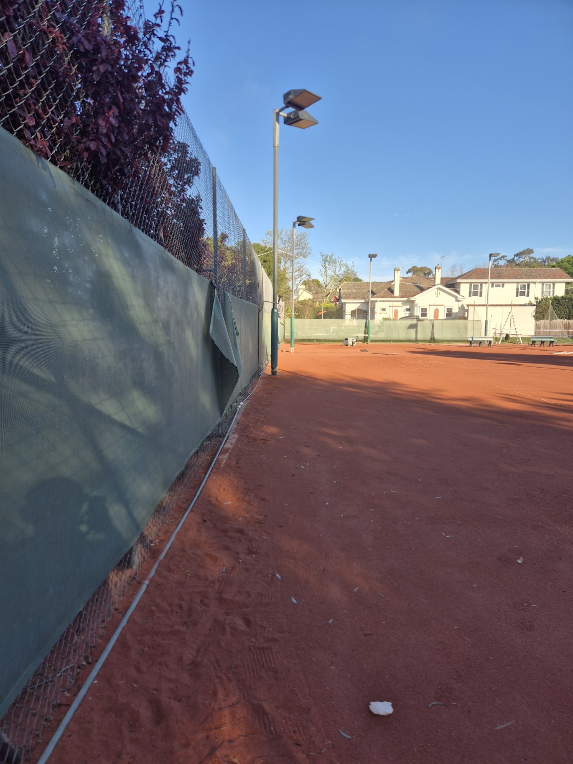 Existing galvanised mesh and windscreens along the court boundary before replacement