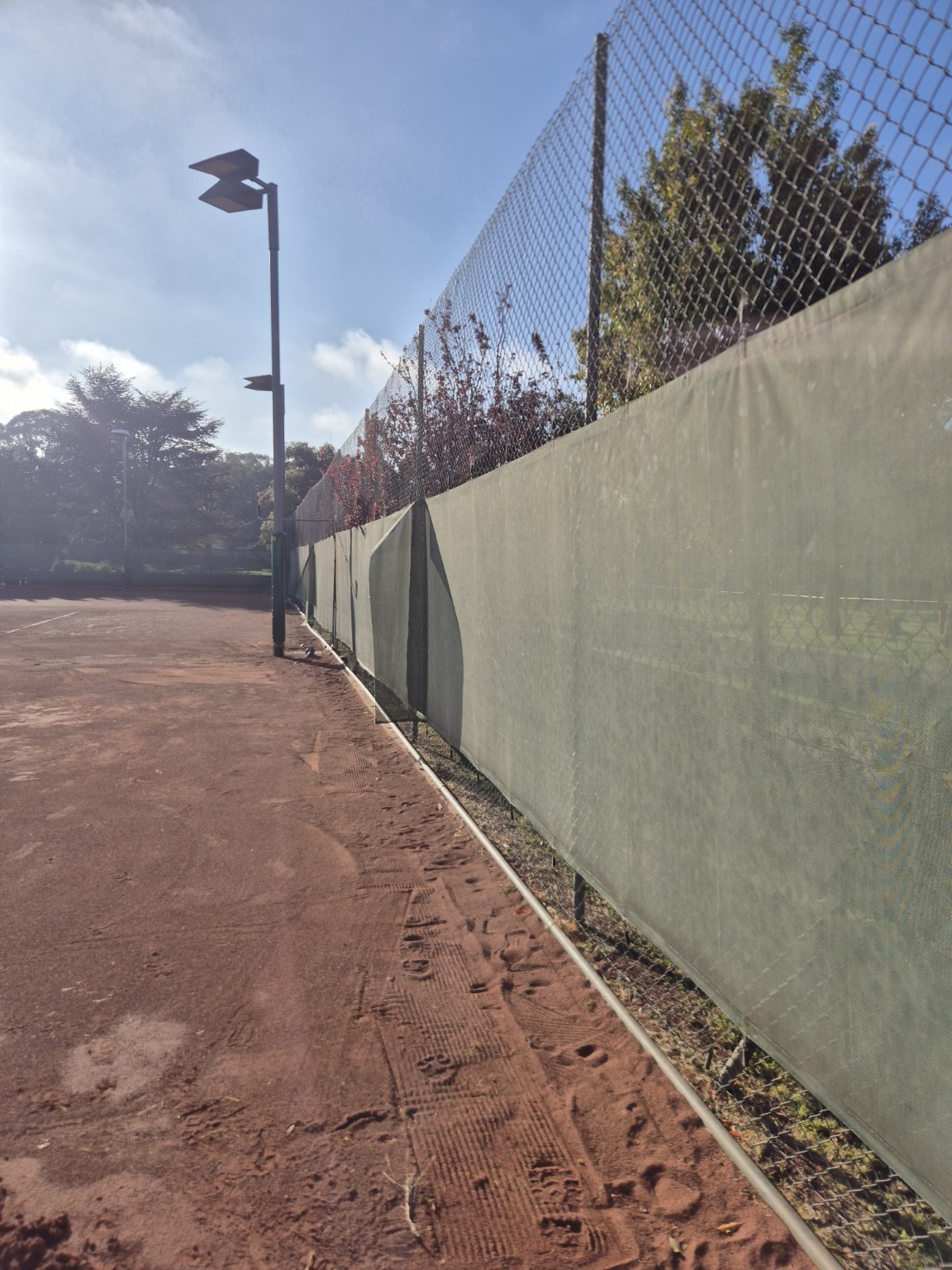 Original fence line and green windscreens before the remaining section was renovated