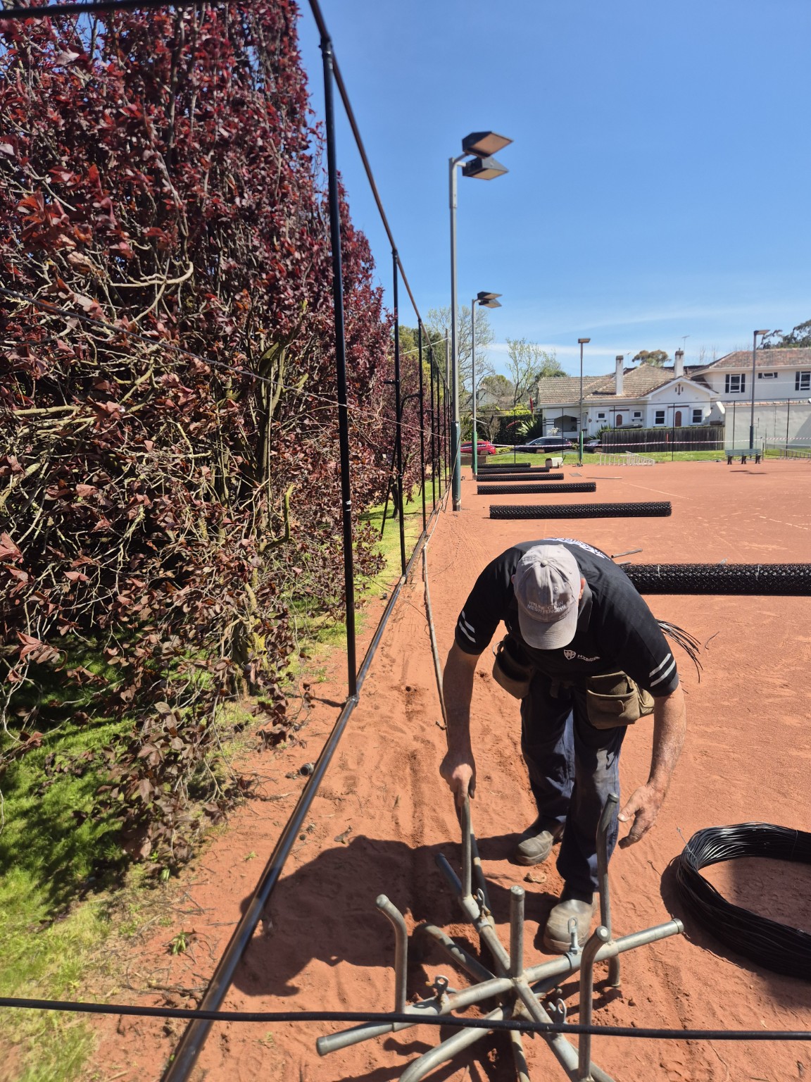 Hyline team member preparing wire during the Willison Park tennis court fence renovation